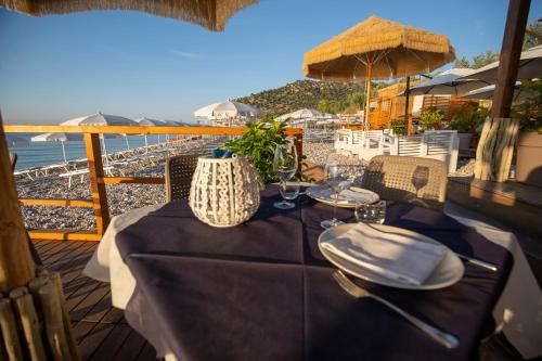 a table with a blue table cloth on a balcony with the ocean at Ferienwohnung ulivo mit Pool und Privatstrand in Mattinata