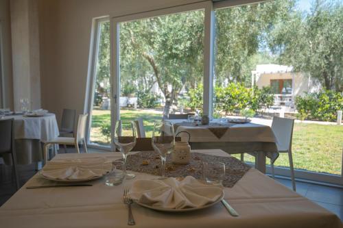 a dining room with a table and a large window at Ferienwohnung ulivo mit Pool und Privatstrand in Mattinata