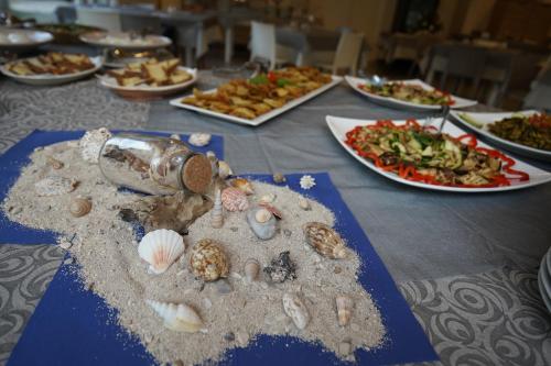 a table with many plates of food on it at Ferienwohnung ulivo mit Pool und Privatstrand in Mattinata