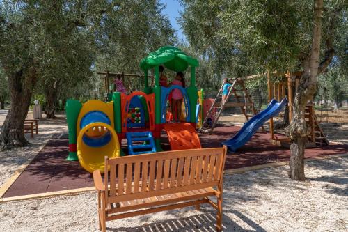 a playground in a park with a bench at Ferienwohnung ulivo mit Pool und Privatstrand in Mattinata