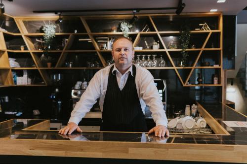 a man standing behind a counter in a bar at Motel Almy in Zenica