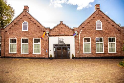 a large brick building with a large door at Hotel Aan De Singel in Delfzijl