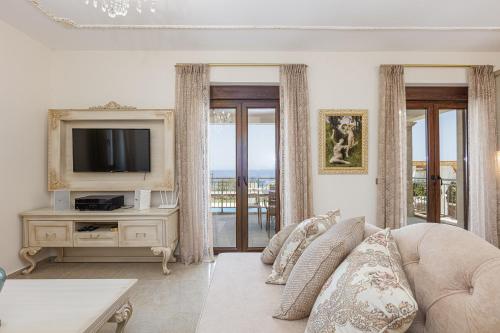 a living room with a couch and a tv at Agapi Villas I & II, Seaside Retreats with Pool & BBQ, By ThinkVilla in Panormos Rethymno