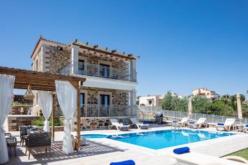 a villa with a swimming pool and a house at Agapi Villas I & II, fairytale seaside retreats, By ThinkVilla in Panormos Rethymno
