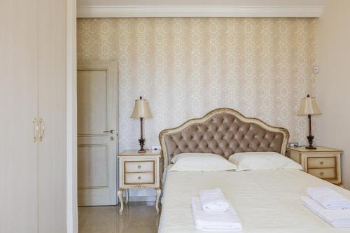 a bedroom with a large bed with two nightstands and two lamps at Agapi Villas I & II, Seaside Retreats with Pool & BBQ, By ThinkVilla in Panormos Rethymno
