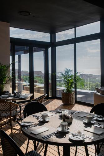 a dining room with tables and chairs and large windows at The Capital Zimbali in Ballito