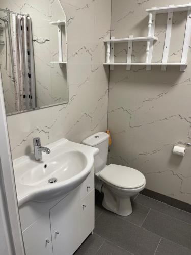 a white bathroom with a toilet and a sink at Hostel ELDORADO in Końskie