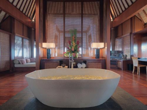 
a large white tub sitting in a large room at The Legian Seminyak, Bali in Seminyak

