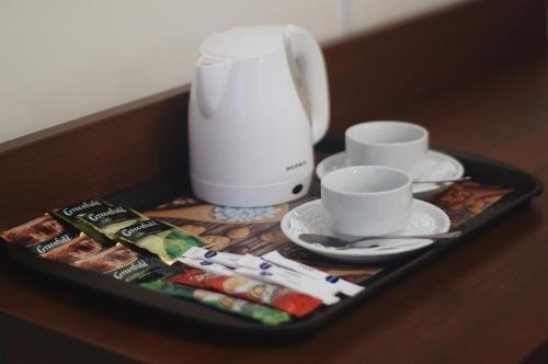 ein Tablett mit zwei Tassen und einem Mixer auf dem Tisch in der Unterkunft Kosmos Hotel in Jaroslawl
