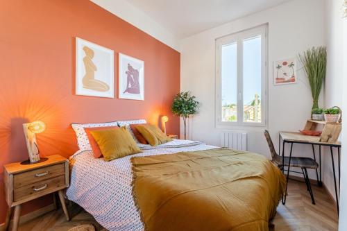 - une chambre avec des murs orange, un lit et un bureau dans l'établissement La ColocXL - Magnifique duplex 110 m² - 5 chambres + parking, à La Ciotat
