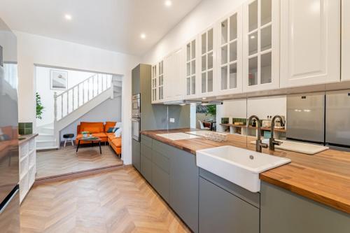 une cuisine ouverte avec un évier et un salon dans l'établissement La ColocXL - Magnifique duplex 110 m² - 5 chambres + parking, à La Ciotat