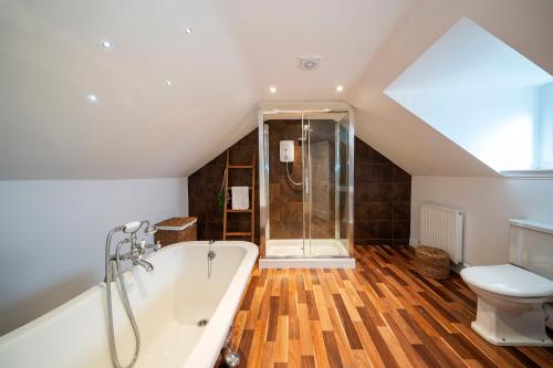 een badkamer op zolder met een bad en een toilet bij Regal Residence in Broughty Ferry