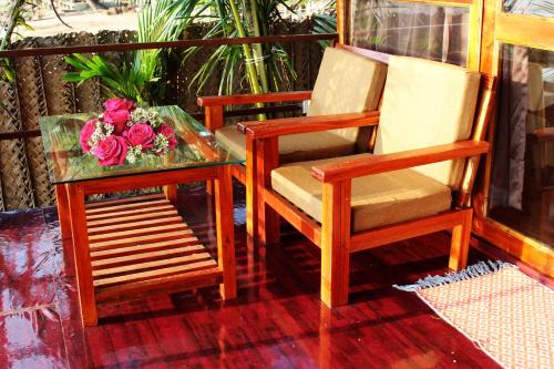 two chairs and a table with flowers on a porch at Agonda Wellness in Agonda