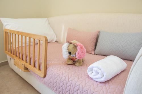a teddy bear sitting on a pink bed at il giardino in Minia