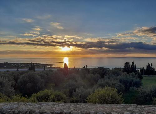 a sunset over the water with the sun setting at il giardino in Minia