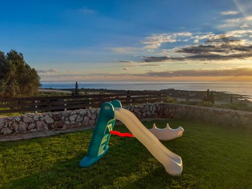 two childrens play equipment on the grass near the water at il giardino in Minia