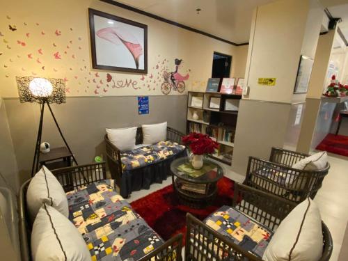 a living room with two beds and a couch at Amax Inn Makati in Manila