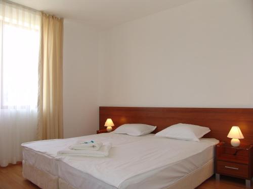 a bedroom with a bed with two towels on it at Apart Hotel Kasandra in Sunny Beach