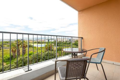 a balcony with a table and chairs and a view of the ocean at Waters Edge Apartments in Cape Town