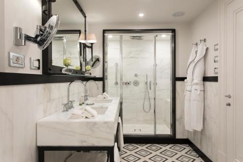 a bathroom with two sinks and a shower at Rocco Forte Hotel De La Ville in Rome
