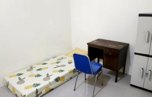 ein Bett mit einem Schreibtisch und einem blauen Stuhl in einem Zimmer in der Unterkunft Kabin Kapsule UI Depok - Male Only in Jakarta
