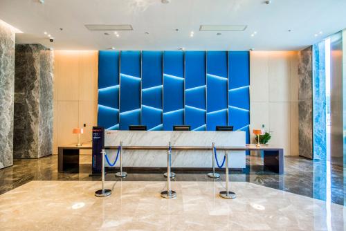 a lobby with a blue wall and a desk at Holiday Inn Express Foshan Beijiao by IHG in Shunde