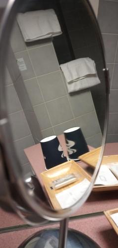 a mirror reflection of a table with towels in a bathroom at Hotel Le Rivage in Olivet