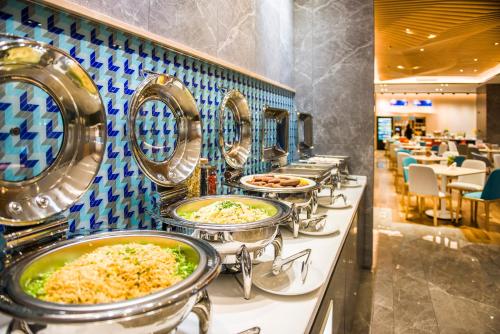 a buffet line with many trays of food at Holiday Inn Express Foshan Beijiao by IHG in Shunde