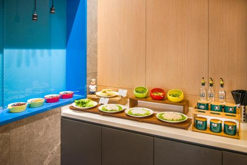 a buffet with plates of food on a counter at Holiday Inn Express Foshan Beijiao by IHG in Shunde