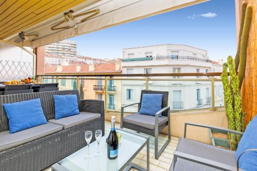een terras met een tafel en stoelen op een balkon bij Le Charme YourHostHelper in Cannes