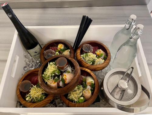 three bowls of food in a tray with a bottle of wine at SeVi Boutique Hotel in Matemwe