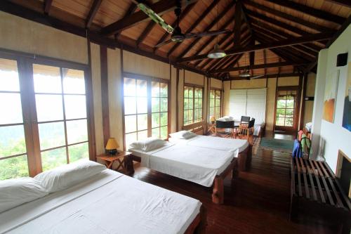 a large room with three beds and a table at Lands End Kandy in Kandy
