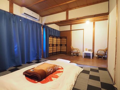 a bed in a room with blue curtains at 四国旅行のHUB拠点 古民家ゲストハウス heso camp in Miyoshi
