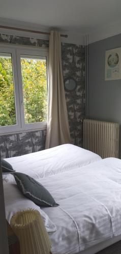 a bedroom with a white bed and two windows at Hotel Le Rivage in Olivet