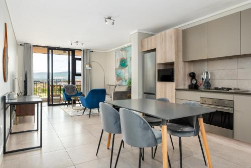 a kitchen and dining room with a table and chairs at Waters Edge Apartments in Cape Town