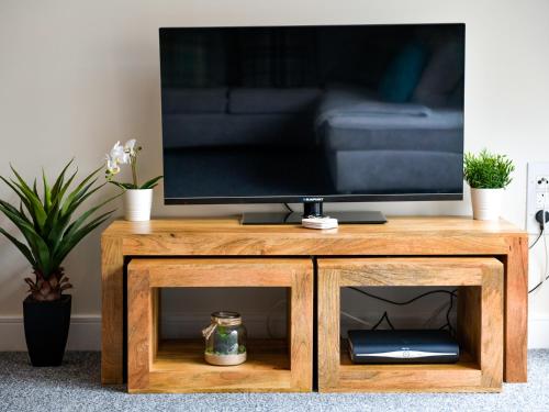 a television on top of a wooden tv stand at Swansea Marina - Sleeps 4 - Underground parking in Swansea