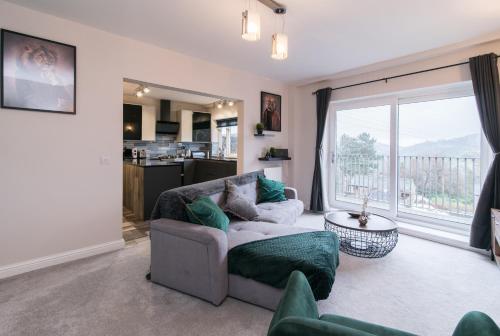 a living room with a couch and a large window at Immaculate 3 Bed House - Stunning Balcony Views in Matlock