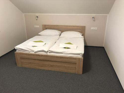 a bed with white sheets and pillows in a room at U Jeřába - komplex C in Horní Věstonice