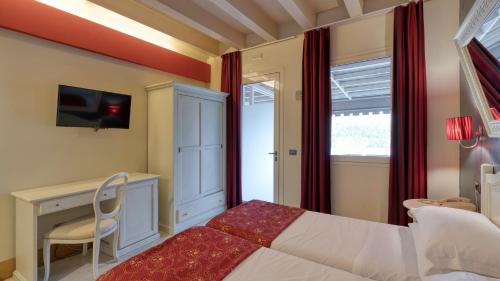 a bedroom with a bed and a desk and a television at Hotel Fiera Di Brescia in Brescia