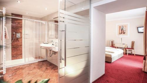 ein Bad mit einer Dusche, einem Waschbecken und einem Bett in der Unterkunft Ferienhaus Austria in Sölden