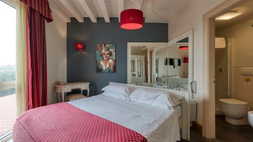 a bedroom with a large bed and a bathroom at Hotel Fiera Di Brescia in Brescia