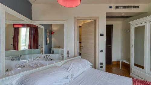 a bathroom with a tub and a large mirror at Hotel Fiera Di Brescia in Brescia