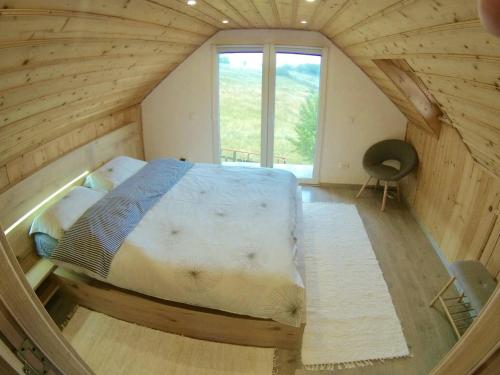 - une chambre avec un lit dans une maison en bois dans l'établissement Cabana Mia Parang, à Petroşani