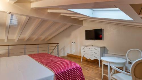 a bedroom with a bed and a tv and a table at Hotel Fiera Di Brescia in Brescia