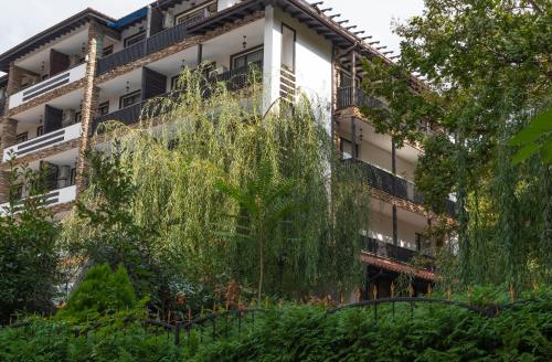 an apartment building with trees in front of it at The Green Paradise Apartments in Primorsko