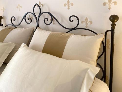 a metal bed with white pillows in a bedroom at Villa Lina in Tremezzo