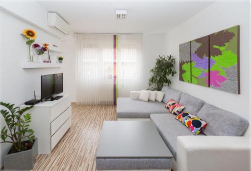 sala de estar con sofá y TV en Mentha Apartments Deluxe - MAD, en Budapest