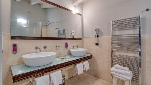 a bathroom with two sinks and a mirror at Hotel Fiera Di Brescia in Brescia