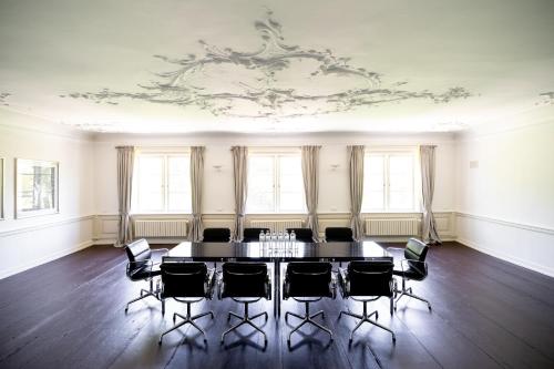 a table and chairs in a room with a ceiling at Hotel Gut Kaden in Alveslohe