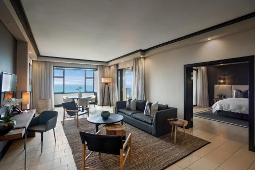 a hotel room with a bed and a living room at The Capital Zimbali in Ballito